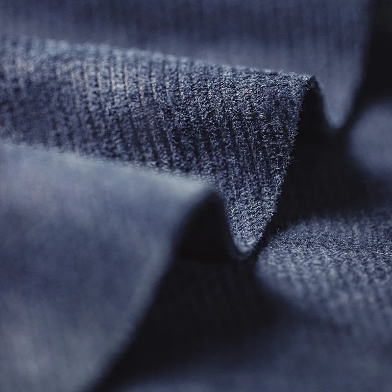 Gros plan macro sur la texture veloutée du daim bleu marine montrant les fibres textiles
