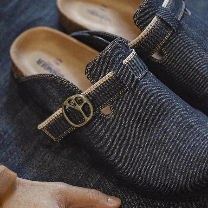 Vue de haut des mules en denim sur une surface sol en denim bleu foncé