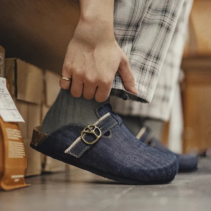 Personne portant les mules en denim avec un pantalon à carreaux et des chaussettes grises