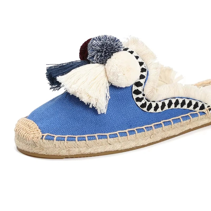Avant de la mule espadrille bleue avec pompons multicolores et couture en corde.