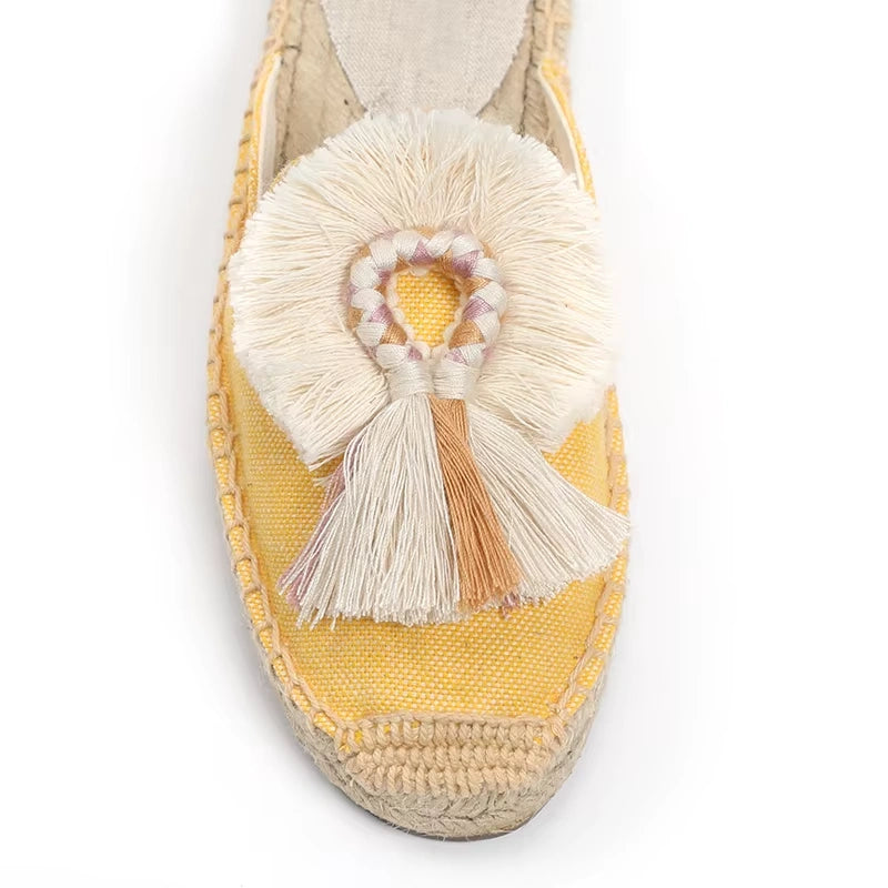 Mule espadrille jaune tressée avec détail en pompon crème et rose, gros plan sur l’avant.