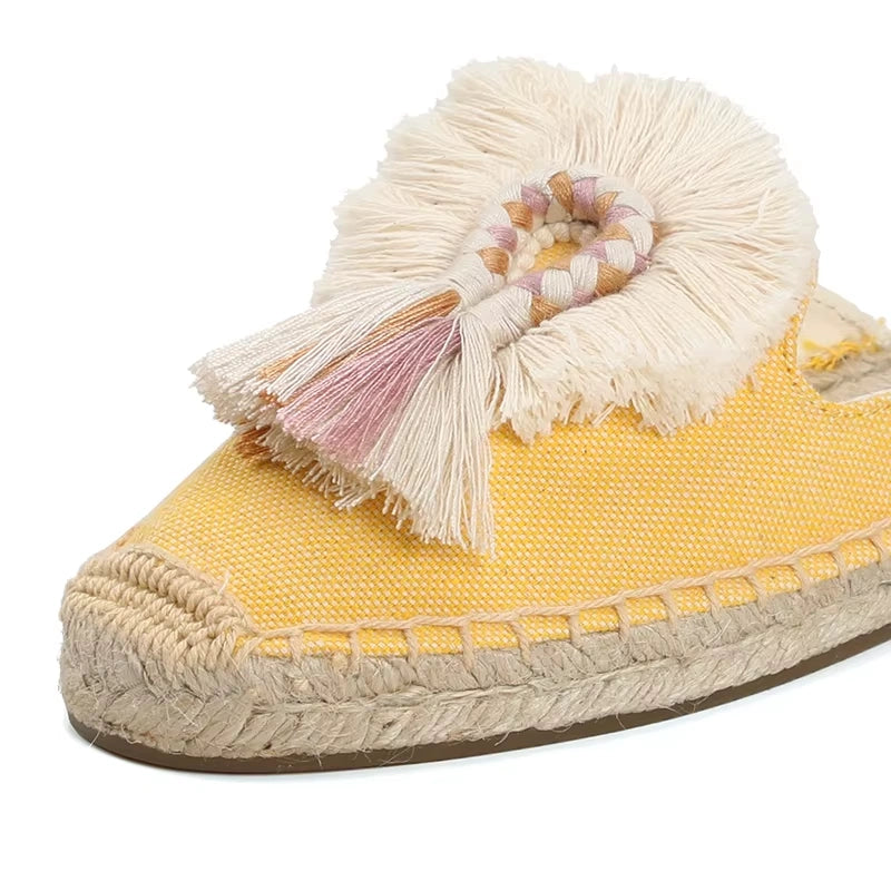 Gros plan sur la mule espadrille jaune tressée, tressage chanvre et pompon décoratif crème.