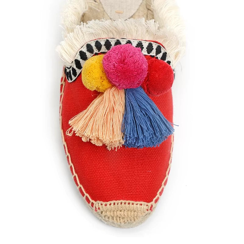 Mule espadrille rouge décorée de pompons et franges en gros plan