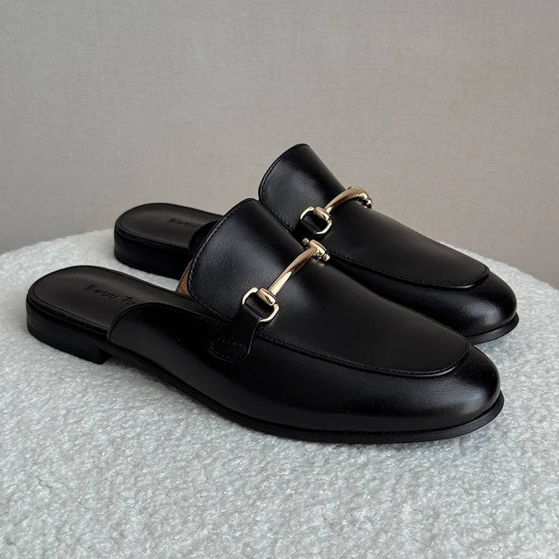 Mules Femme Chic en Cuir Noir tenues à la main, montrant la finition lisse du cuir et l’intérieur en cuir véritable