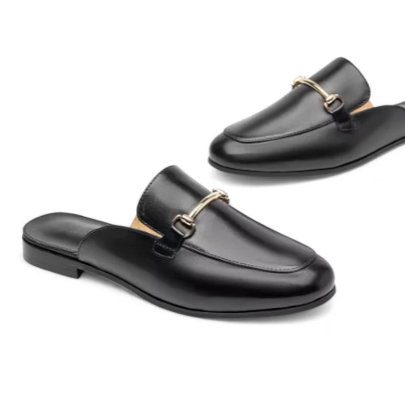 Mules Femme Chic en Cuir Noir vues en paire sur fond blanc, avec un accent sur le dessus arrondi et l’ornement doré