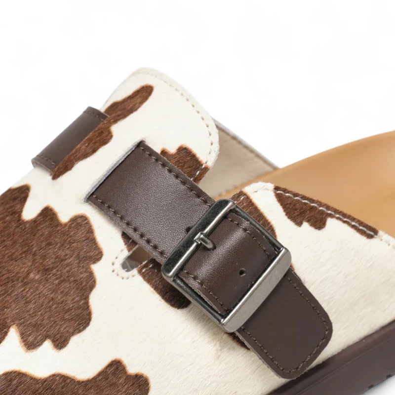 Gros plan sur les Mules Vache Marron et Beige femme, mettant en avant la boucle métallique et le cuir imprimé.
