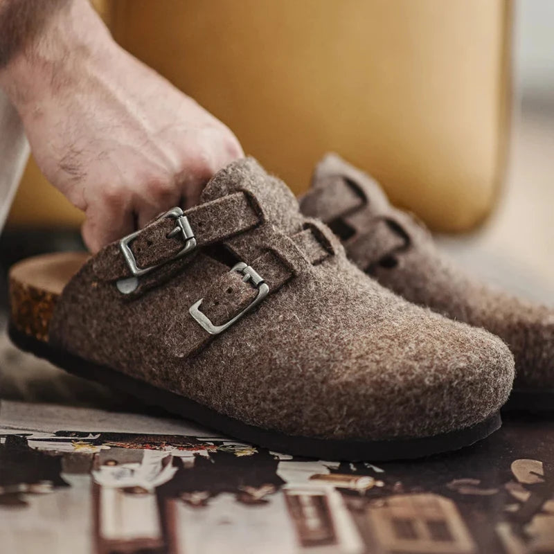 Main portant les mules en laine marron gros plan détail double boucle réglable semelle liège