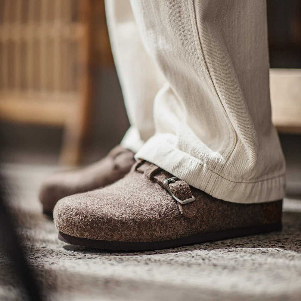 Mules laine marron portées pantalon beige clair sur sol beige vue arrière boucles métalliques