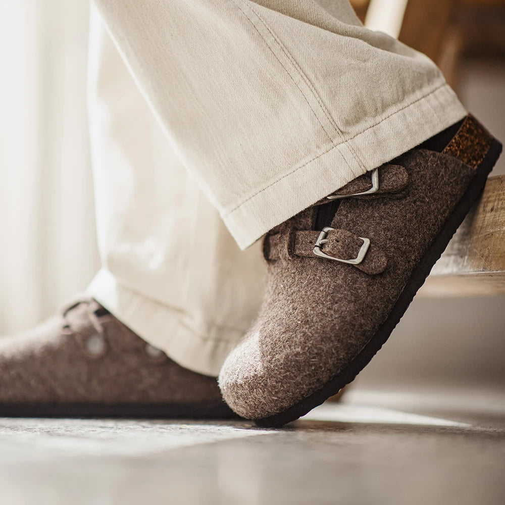 Mules laine marron portées debout avec pantalon beige clair vue trois-quarts double boucles semelle EVA noire